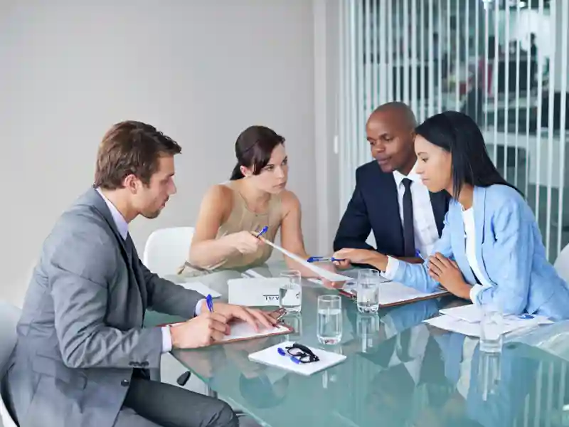 Group of businessmen and women strategizing during a meeting.